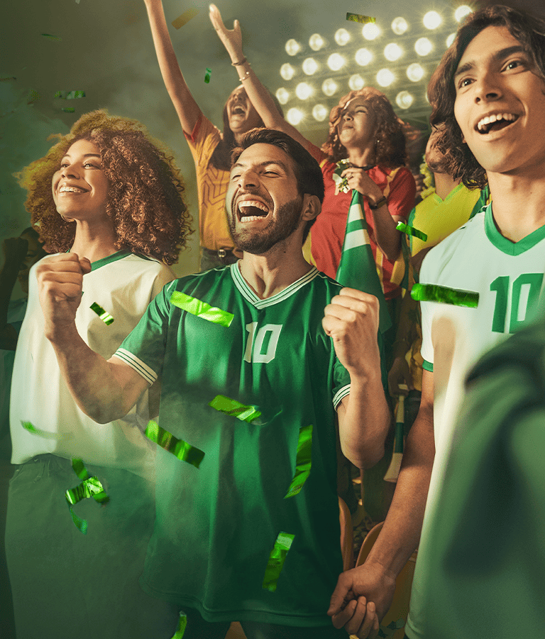 Fans celebrando en el estadio durante un partido de fútbol